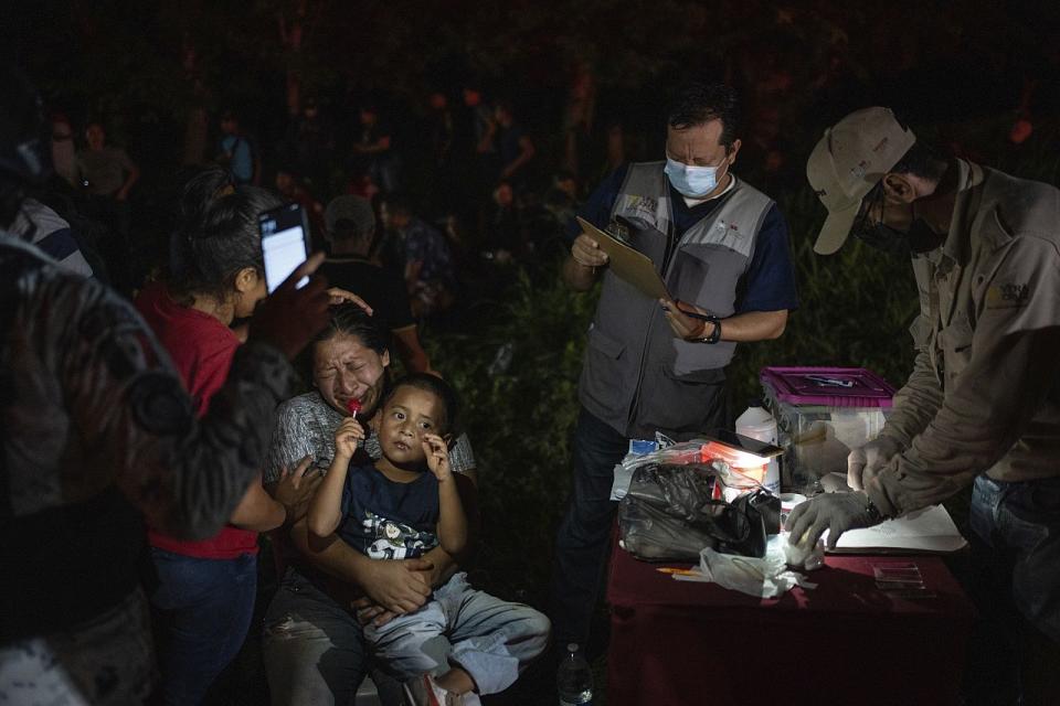 Migrants who were traveling to the U.S. inside a tractor-trailer are detained by Mexican immigration agents and National Guard members, in Veracruz, Mexico