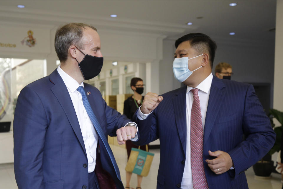 Britain's Foreign Secretary Dominic Raab, left, greets with an elbow bump with Cambodian's Environment Minister Say Sam Al after a meeting in Phnom Penh, Cambodia Wednesday, June 23, 2021. Raab is on his two-day official visit to Cambodia. (AP Photo/Heng Sinith)