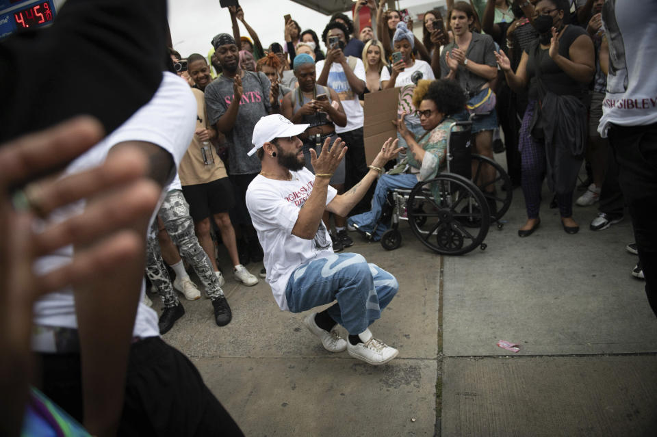 CORRECTS SECOND SENTENCE - People dance in vogue style during a vigil to memorialize O'Shae Sibley at a gas station on Friday, Aug. 4, 2023, in the Brooklyn borough of New York. Sibley, a gay man, was fatally stabbed at the gas station after a confrontation between a group of friends dancing to a Beyoncé song and several young men who taunted them. (AP Photo/Tracie Van Auken)