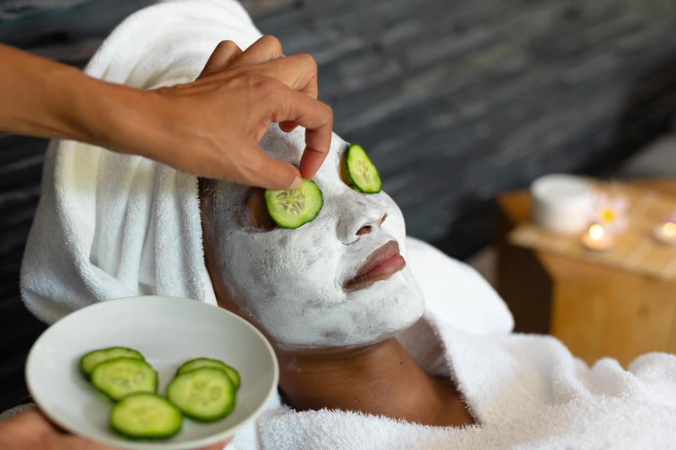 woman with cucumbers on her eyes and wearing a DIY face maks to show cucumber benefits for skin