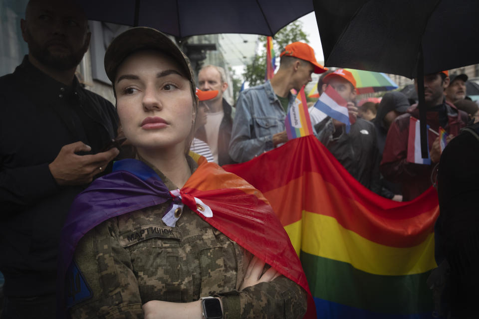 A woman soldier wrapped in the LGBT flag attends a Pride march in Kyiv, Ukraine, Sunday, June 16, 2024. Several hundred LGBT Ukrainian servicemen and other protesters joined the pride march in central Kyiv Sunday seeking legal reforms to allow people in same-sex partnerships to take medical decisions for wounded soldiers and bury victims of the war with Russia that extended across Ukraine more than two years ago. (AP Photo/Efrem Lukatsky)