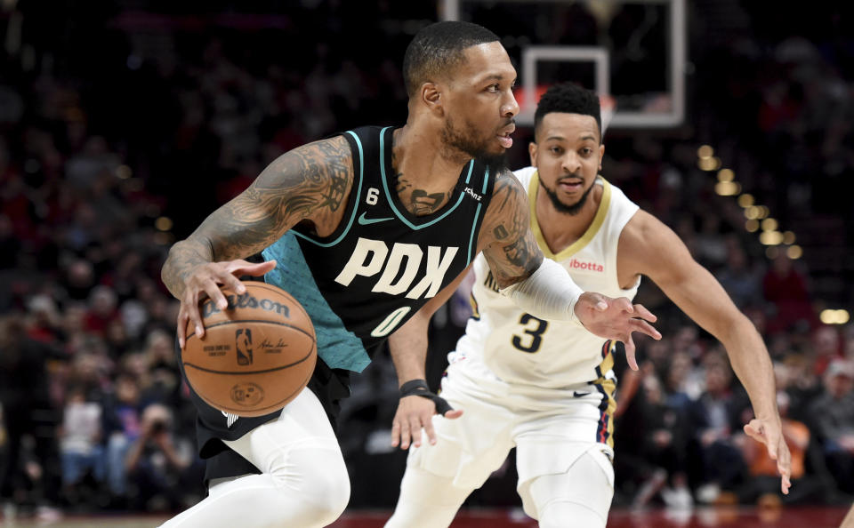 Portland Trail Blazers guard Damian Lillard, left, drives to the basket against New Orleans Pelicans guard CJ McCollum during the first half of an NBA basketball game in Portland, Ore., Wednesday, March 1, 2023. (AP Photo/Steve Dykes)