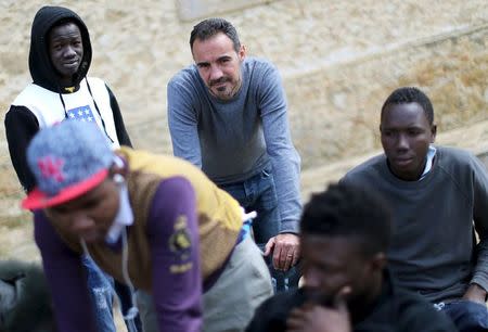 Daniele Cutugno (C), a psychologist at the Caltagirone shelter, is seen next to adolescent migrants at the courtyard of the immigration centre in Caltagirone, Sicily March 18, 2015. REUTERS/Alessandro Bianchi