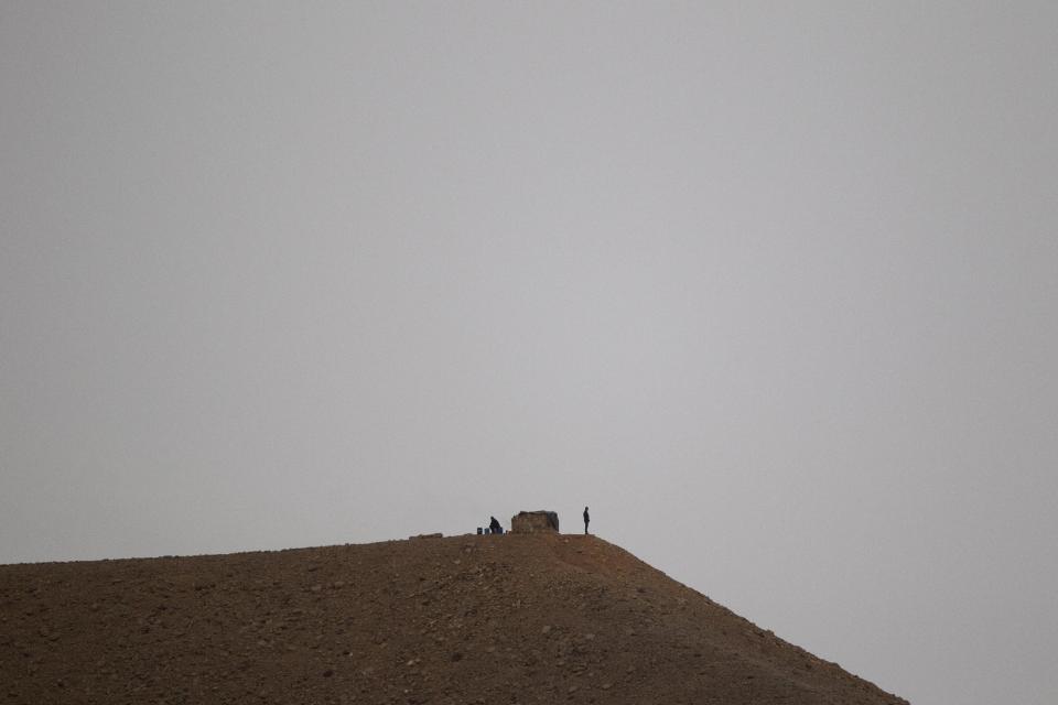 Two Egyptian soldiers in their military position stand guard along the Egypt-Israel border seen from the Red Sea resort city of Eilat, southern Israel, Sunday, March 9, 2014. A senior security official in Egypt said a missile shipment seized by Israel last week was destined for militants in either the Sinai Peninsula or the Gaza Strip. (AP Photo/Ariel Schalit)