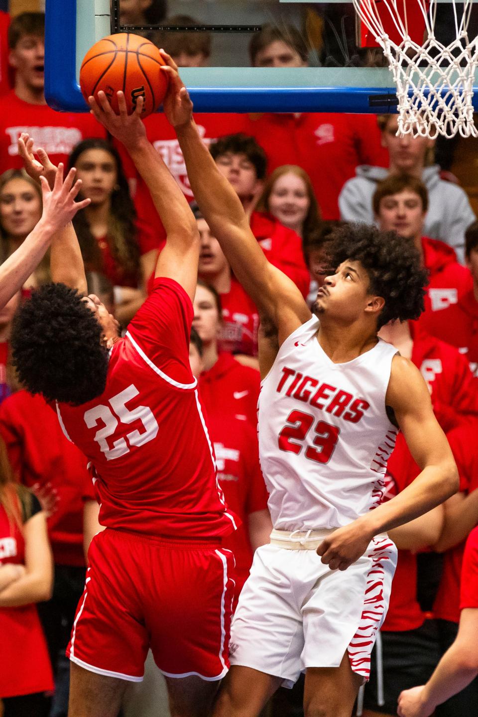 Fishers' Keenan Garner (23) blocks Crown Point's Jaden Skulfield (25) during the Fishers vs. Crown Point boys semistate basketball semifinal game Saturday, March 16, 2024 at Northside Gym in Elkhart.