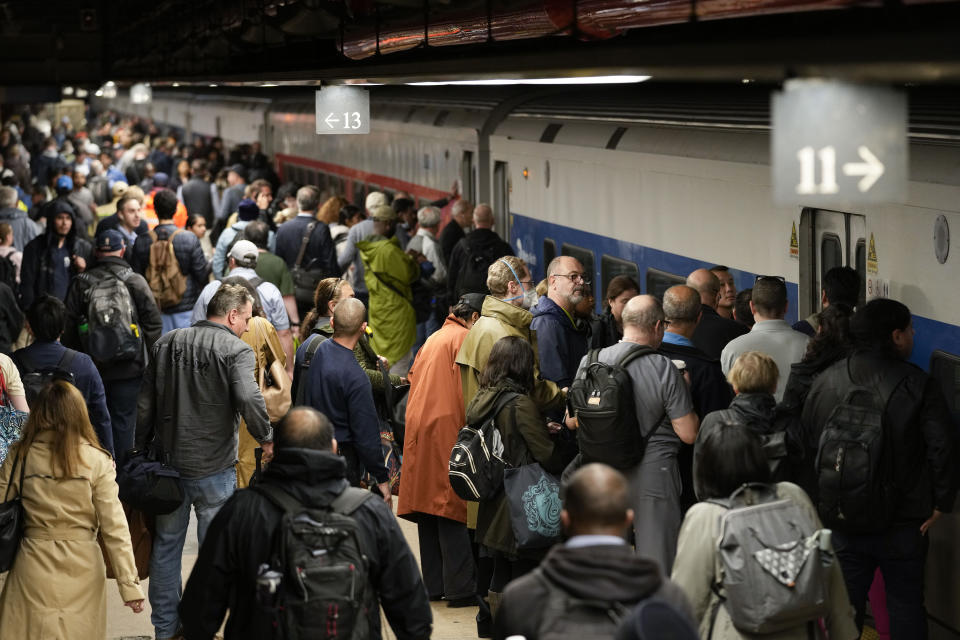 Commuters stand on a track around the closed doors of a train they thought would run on the Hudson River line at Grand Central Terminal, Friday, Sept. 29, 2023, in New York. The train was not in service due to heavy rains in the area. (AP Photo/Mary Altaffer)