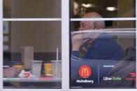 Customer sit and eat at a McDonald's in Wheeling, Ill., Thursday, March 14, 2024. System failures at McDonald's were reported worldwide Friday, shuttering some restaurants for hours and leading to social media complaints from customers, in what the fast food chain called a “technology outage” that was being fixed. (AP Photo/Nam Y. Huh)