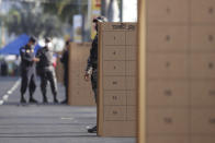 Police officers stand guard during legislative and local elections, at a polling place in San Salvador, El Salvador, Sunday, Feb. 28, 2021. Sunday's elections in El Salvador are seen as a referendum on whether to break the congressional deadlock that has tied the hands of upstart populist President Nayib Bukele. (AP Photo/Salvador Melendez)