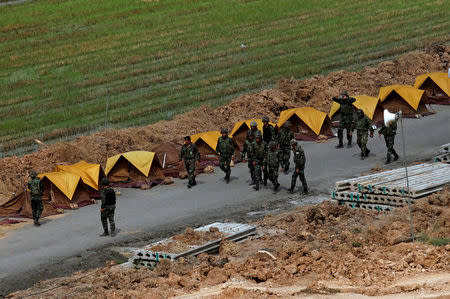 Soldiers walk past tents on the premises of the Wat Phra Dhammakaya temple during an inspection of the temple, in Pathum Thani province, Thailand March 10, 2017. REUTERS/Chaiwat Subprasom