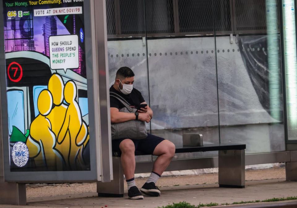 Un hombre se sienta en la parada de autobús con una máscara en la cara en la ciudad de Nueva York, Estados Unidos, el 6 de junio de 2023 (Agencia Anadolu a través de Getty Images)