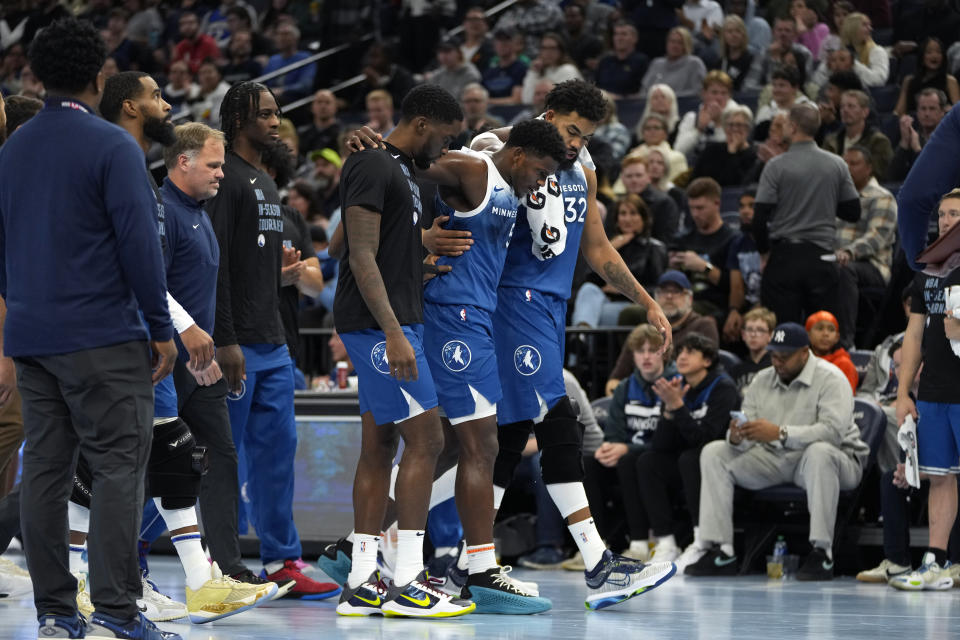 Minnesota Timberwolves guard Anthony Edwards, center, is helped off the court after sustaining an injury during the second half of an NBA basketball In-Season Tournament game against the Oklahoma City Thunder, Tuesday, Nov. 28, 2023, in Minneapolis. (AP Photo/Abbie Parr)