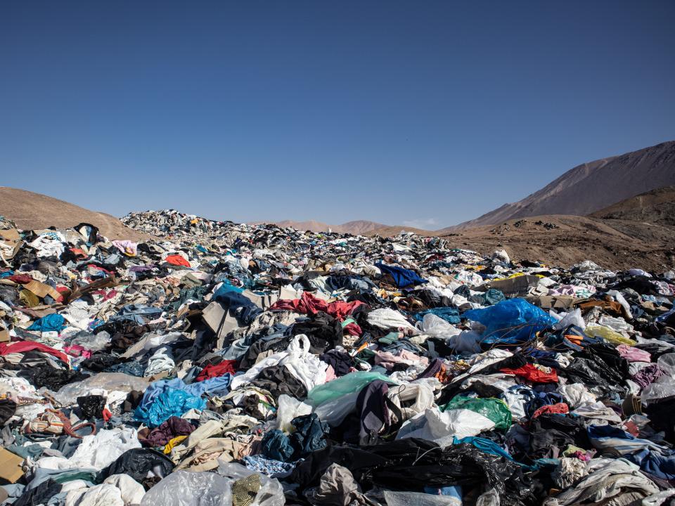 A mountain of used clothes in the desert hills of Chile