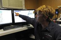 A photo taken on April 16, 2014, and released on April 17, 2014, shows Craig Turner from Phoenix International monitoring the Artemis' depth and speed as the Autonomous Underwater Vehicle scans the ocean floor for missing flight MH370