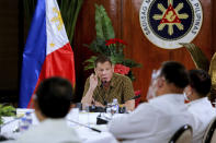 In this photo provided by the Malacanang Presidential Photographers Division, Philippine President Rodrigo Duterte, center, gestures as he meets members of the Inter-Agency Task Force on the Emerging Infectious Diseases at the Malacanang presidential palace in Manila, Philippines late Monday Sept. 28, 2020. Only one southern Philippine province and its war-battered capital will be placed under a mild lockdown and the rest of the country will be put under more relaxed quarantine restrictions next month to boost the battered economy despite the country having the most number of coronavirus infections in Southeast Asia. (Robinson Ninal Jr./Malacanang Presidential Photographers Division via AP)