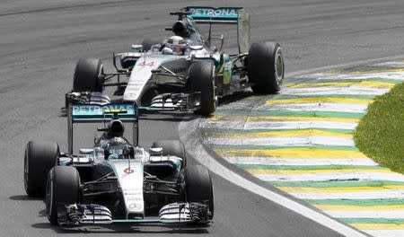 Mercedes Formula One driver Nico Rosberg (front) of Germany and team mate Lewis Hamilton of Britain go into a turn together during the start of the Brazilian F1 Grand Prix in Sao Paulo, Brazil, November 15, 2015. REUTERS/Paulo Whitaker