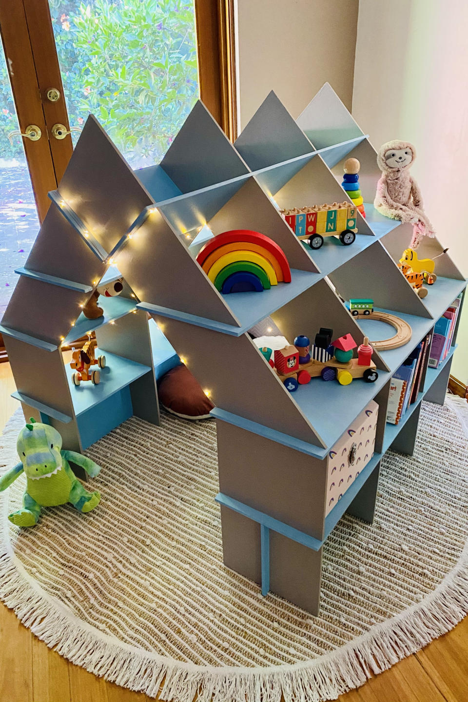 Bump2Bub's 'Creative Cubby', painted blue and set up with toys stored in the sides