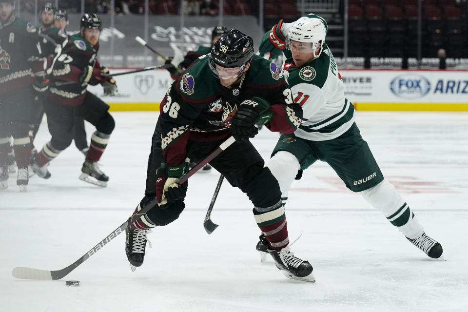 Arizona Coyotes right wing Christian Fischer (36) shields Minnesota Wild left wing Zach Parise from the puck during the second period during an NHL hockey game Friday, March 5, 2021, in Glendale, Ariz. (AP Photo/Rick Scuteri)