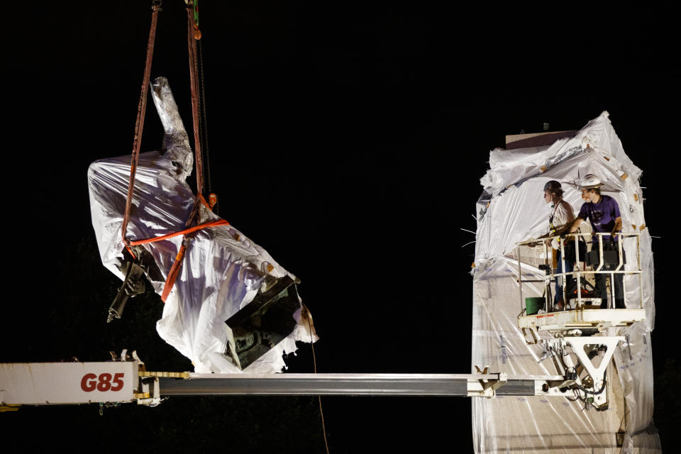 FILE - In this July 24, 2020, file photo, a work crew removes the Columbus statue in Grant Park in Chicago. At least 160 Confederate symbols were taken down or moved from public spaces in 2020. That's according to a new count the Southern Poverty Law Center shared with The Associated Press. (Armando L. Sanchez/Chicago Tribune via AP, File)