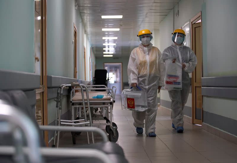 Members of an electoral commission visit a regional hospital during a nationwide vote on constitutional reforms in Tver