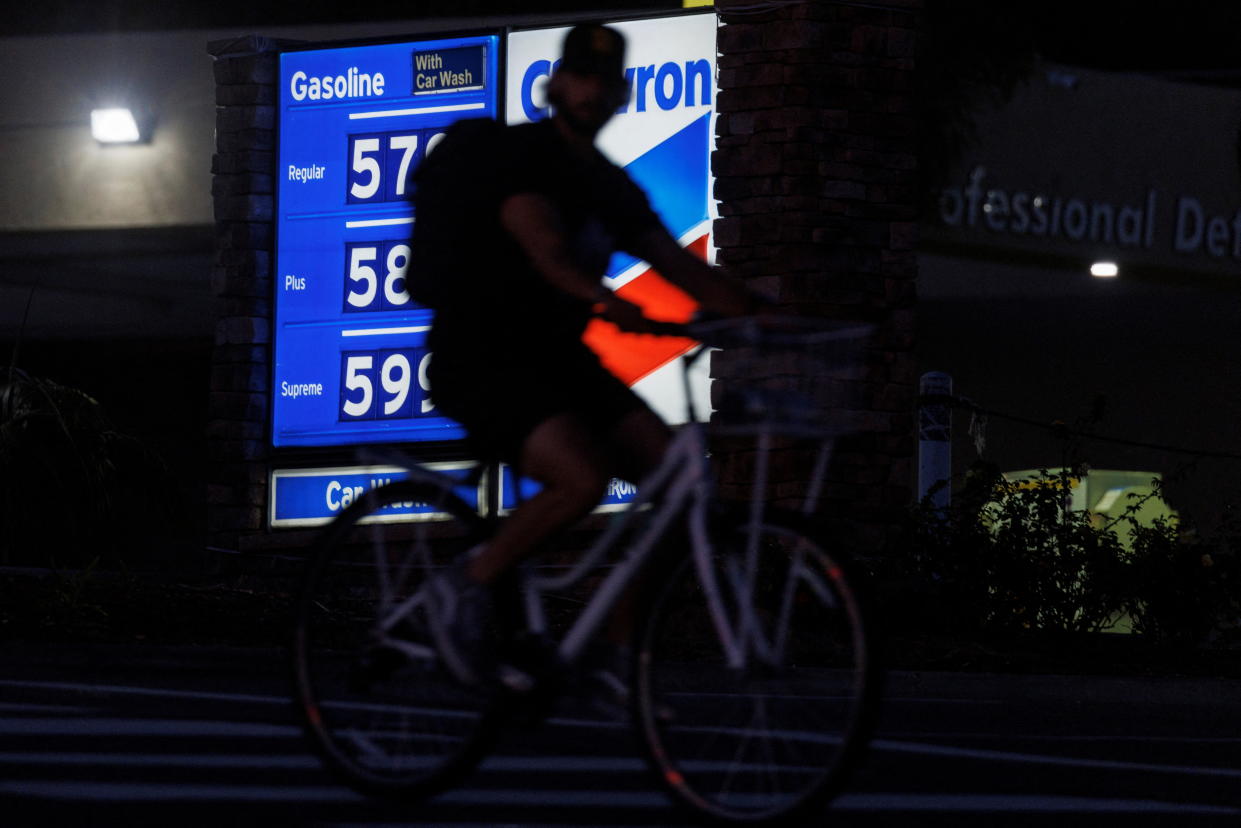 A cyclist rides past a gas station as fuel prices continue to climb close to record setting territory in Encinitas, California, U.S., May 9, 2022.  REUTERS/Mike Blake