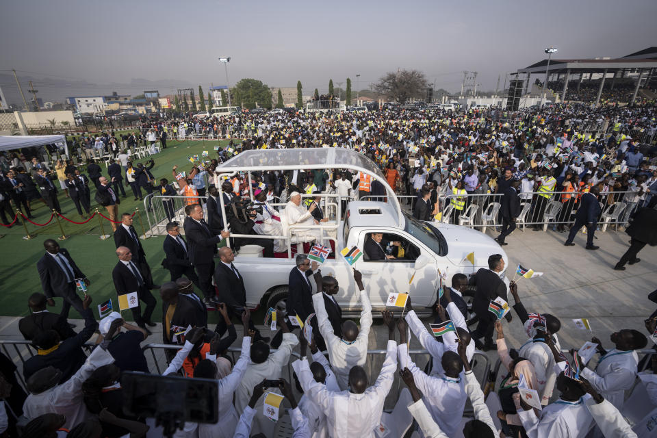 Pope Francis waves as he tours the audience in his vehicle after arriving for a Holy Mass at the John Garang Mausoleum in Juba, South Sudan Sunday, Feb. 5, 2023. Pope Francis is in South Sudan on the final day of a six-day trip that started in Congo, hoping to bring comfort and encouragement to two countries that have been riven by poverty, conflicts and what he calls a "colonialist mentality" that has exploited Africa for centuries. (AP Photo/Ben Curtis)