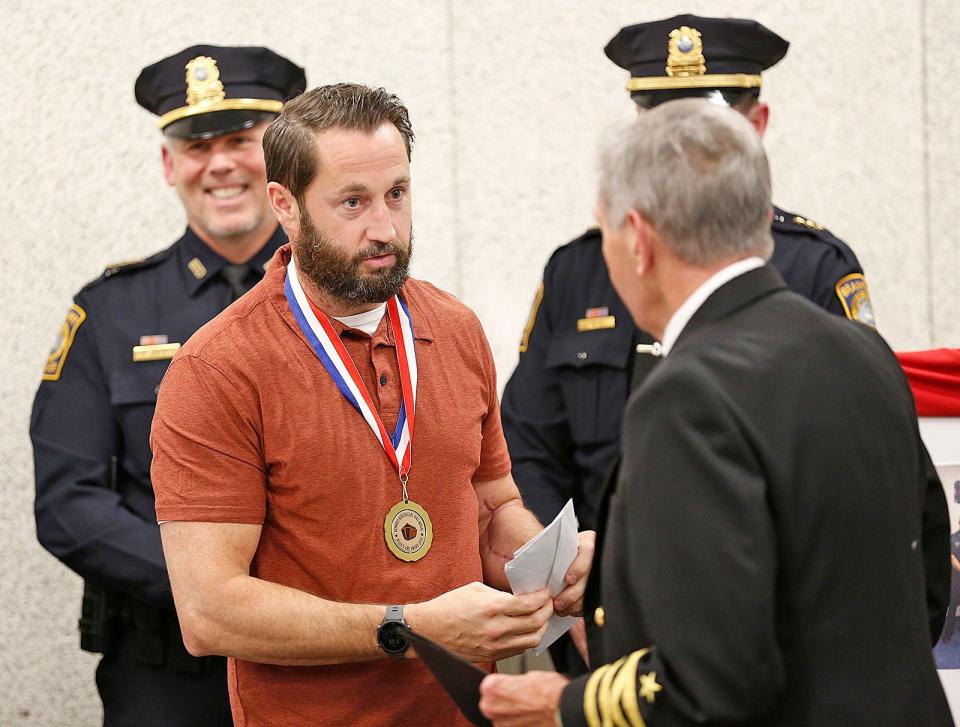 Braintree police officer Bill Cushing receives a World War II Peace Medal at the Braintree police station Thursday, Nov. 11, 2021.