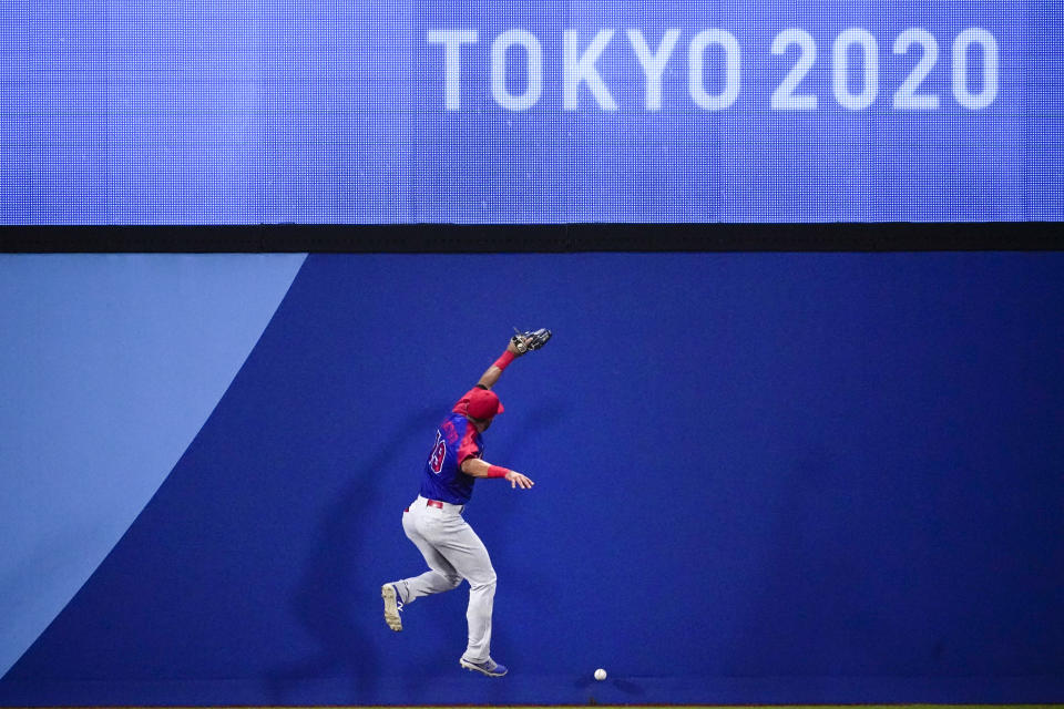 Dominican Republic's Jose Bautista cannot reach a ball hit by South Korea's Kyoungmin Hur in the second inning of a baseball game at the 2020 Summer Olympics, Sunday, Aug. 1, 2021, in Yokohama, Japan. (AP Photo/Sue Ogrocki)