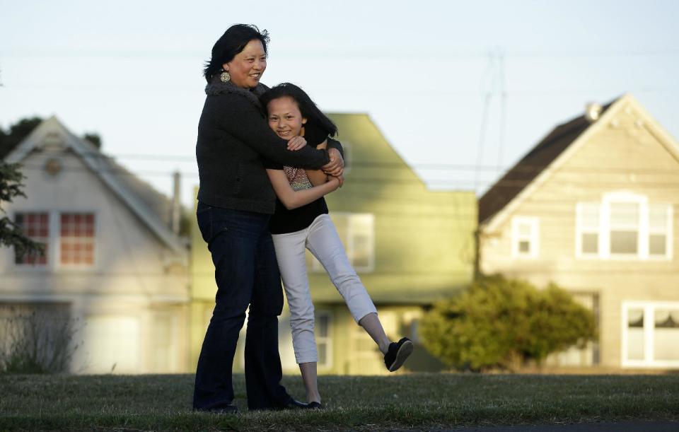 Joyce Chen hugs her daughter Kathryn, 10, as they pose for photographs in San Francisco, Wednesday, May 29, 2013. A new poll finds that one in five unmarried women would consider having a child on their own, and more than a third would consider adopting solo, just one indication of America’s changing family structures. (AP Photo/Jeff Chiu)