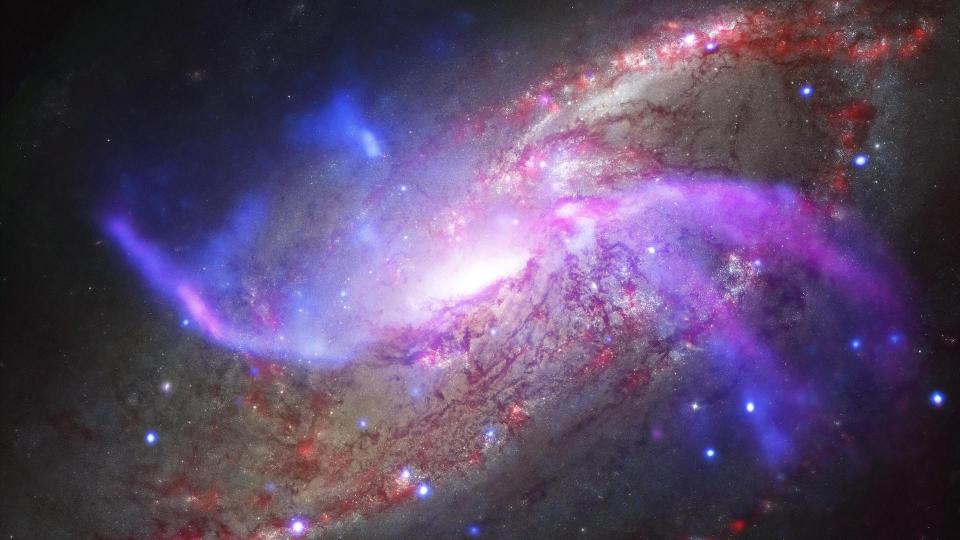  A spiral galaxy with purple and red streaks. 