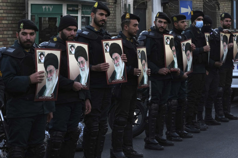 Iranian police officers hold posters of the Supreme Leader Ayatollah Ali Khamenei as they protect the French Embassy during a gathering to protest against the publication of offensive caricatures of Ayatollah Ali Khamenei in the French satirical magazine Charlie Hebdo, in Tehran, Iran, Sunday, Jan. 8, 2023. (AP Photo/Vahid Salemi)