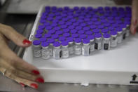 A health worker holds a tray with vials of the Pfizer vaccine for COVID-19 during a priority COVID-19 vaccination program at a community medical center in Sao Paulo, Brazil, Thursday, May 6, 2021. (AP Photo/Andre Penner)