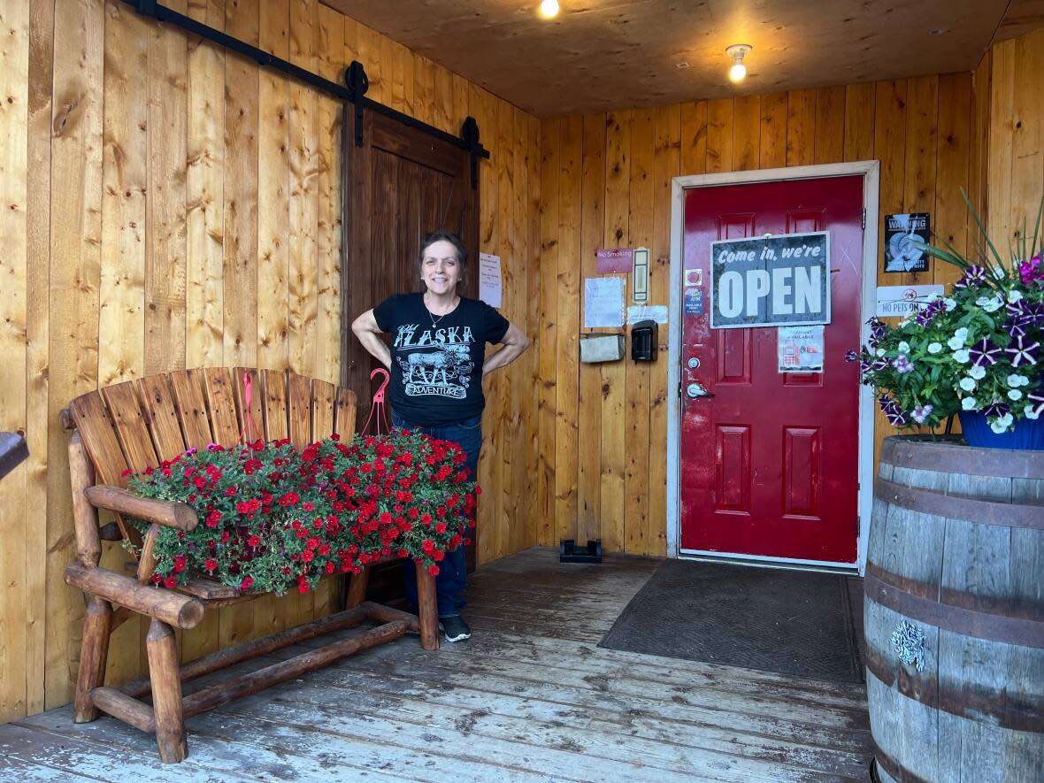 Carmen Hinson stands outside her business, Buckshot Betty's, in Beaver Creek, Yukon. A few weeks ago, she put a 'For Sale' sign out front. (Paul Tukker/CBC - image credit)