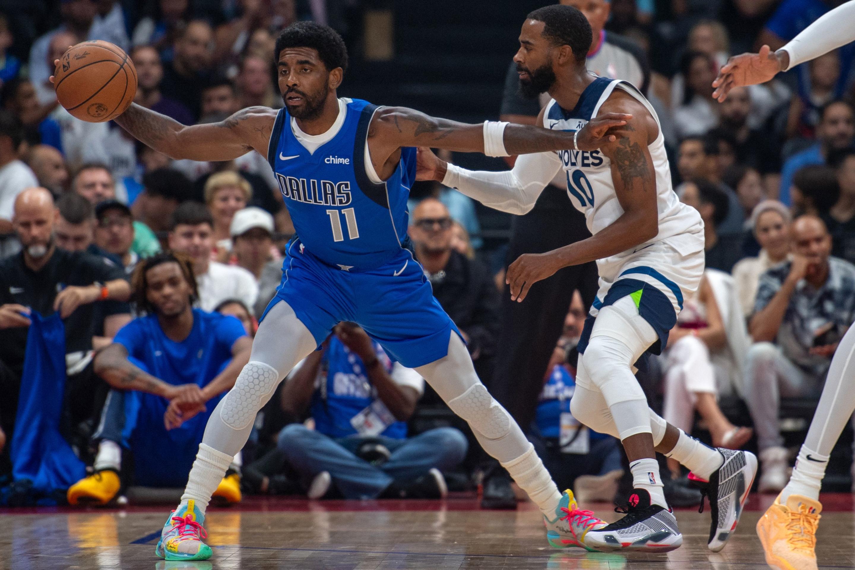 Dallas Mavericks guard Kyrie Irving is guarded by Minnesota Timberwolves guard Mike Conley during an NBA preseason game at the Etihad Arena in Abu Dhabi, United Arab Emirates, on Oct. 5, 2023. (Photo by Ryan LIM / AFP)