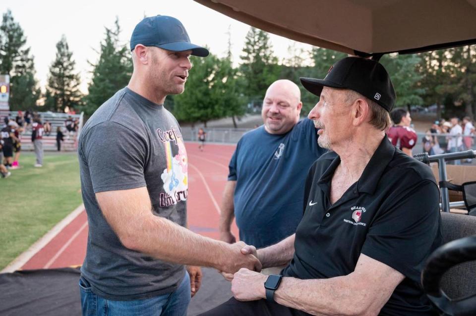 Dustin Smith, left, shakes the hand of his former coach Terry Logue before the game against the Tamalpais Red Tailed Hawks on Sept. 14. Logue coached from 1986-2020.