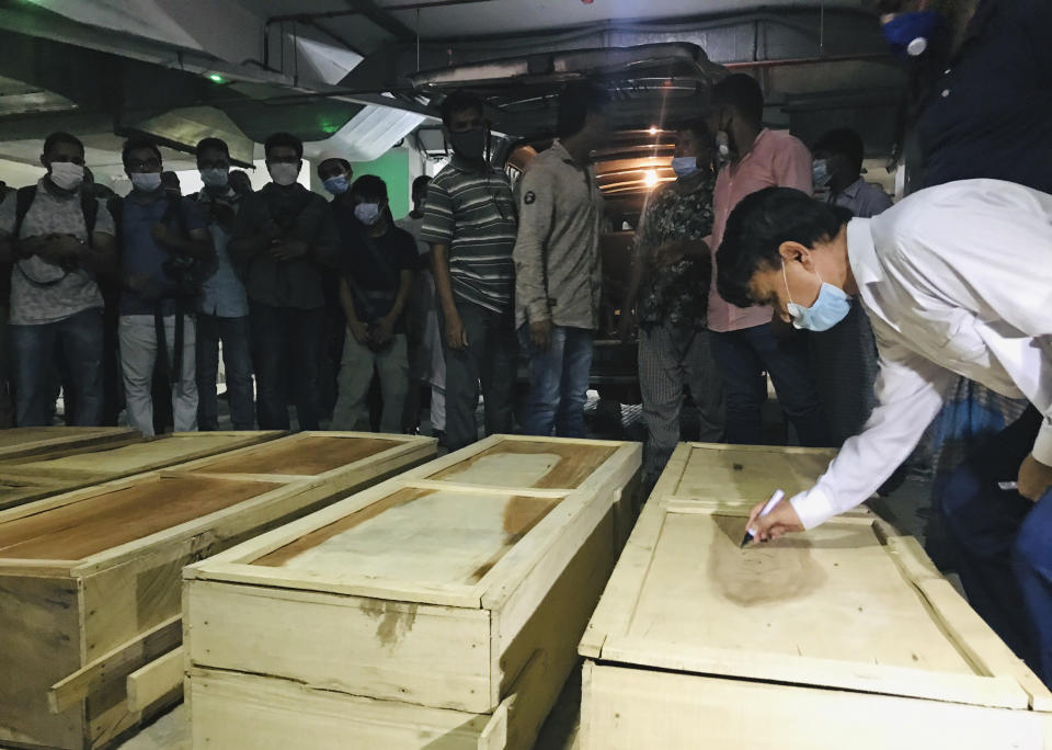 An officer writes the details of a victim of a gas pipeline explosion on a coffin at a hospital in Dhaka, Bangladesh, Saturday, Sept. 5, 2020. An underground gas pipeline near a mosque exploded during evening prayers outside the capital of Bangladesh, leaving at least 11 Muslim worshipers dead and dozens injured with critical burns, officials said Saturday. The blast occurred Friday night as people were finishing their prayers at Baitus Salat Jame Mosque at Narayanganj, local police chief Zayedul Alam said. (AP Photo/Al-emrun Garjon)