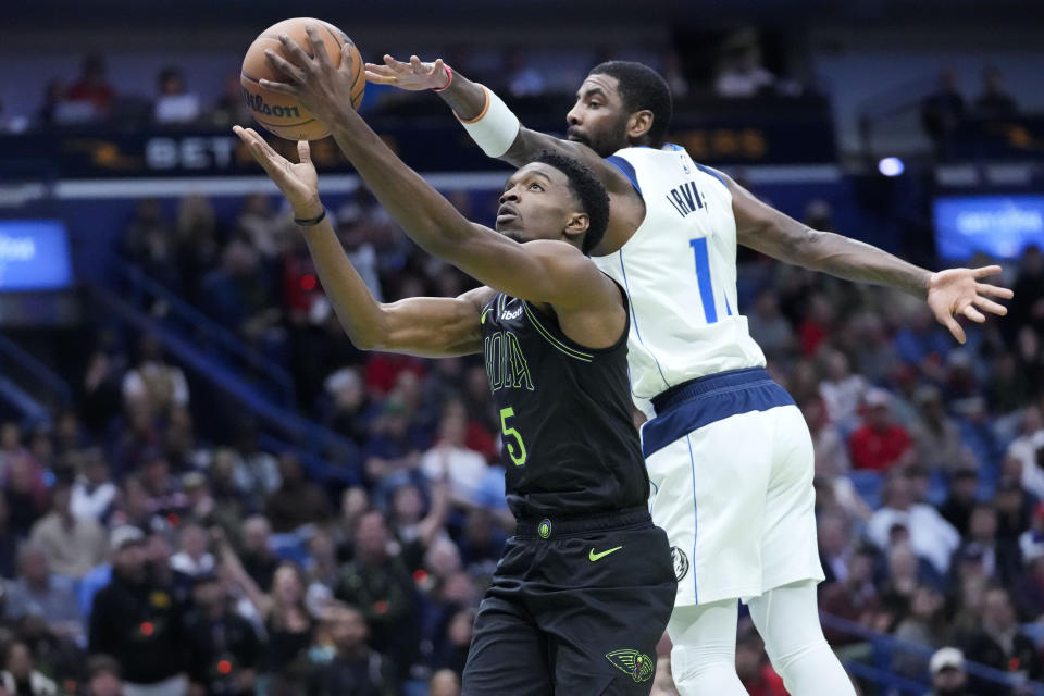 New Orleans Pelicans forward Herbert Jones (5) goes to the basket against Dallas Mavericks guard Kyrie Irving in the first half of an NBA basketball game in New Orleans, Tuesday, Nov. 14, 2023. (AP Photo/Gerald Herbert)