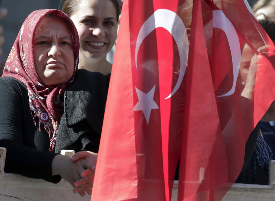 People wait for the arrival of Turkey's President Recep Tayyip Erdogan close to a hotel in Berlin, Germany, Thursday, Sept. 27, 2018. Erdogan will be a guest at that hotel during his two day visit at the German capital. (AP Photo/Michael Sohn)