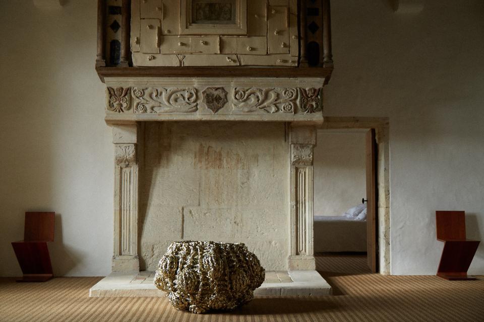 An original fireplace has been enhanced by a ceramic work by artist Elmer Trenkwalder. Ines Dobelle’s “Corbeille de Fruit,” a knitted sculpture, sits in front.