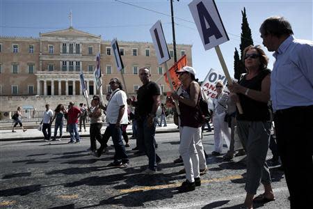 Protesters march holding banners to create the word "Strike" during an anti-government rally in front of the parliament in Athens September 18, 2013. REUTERS/Yorgos Karahalis