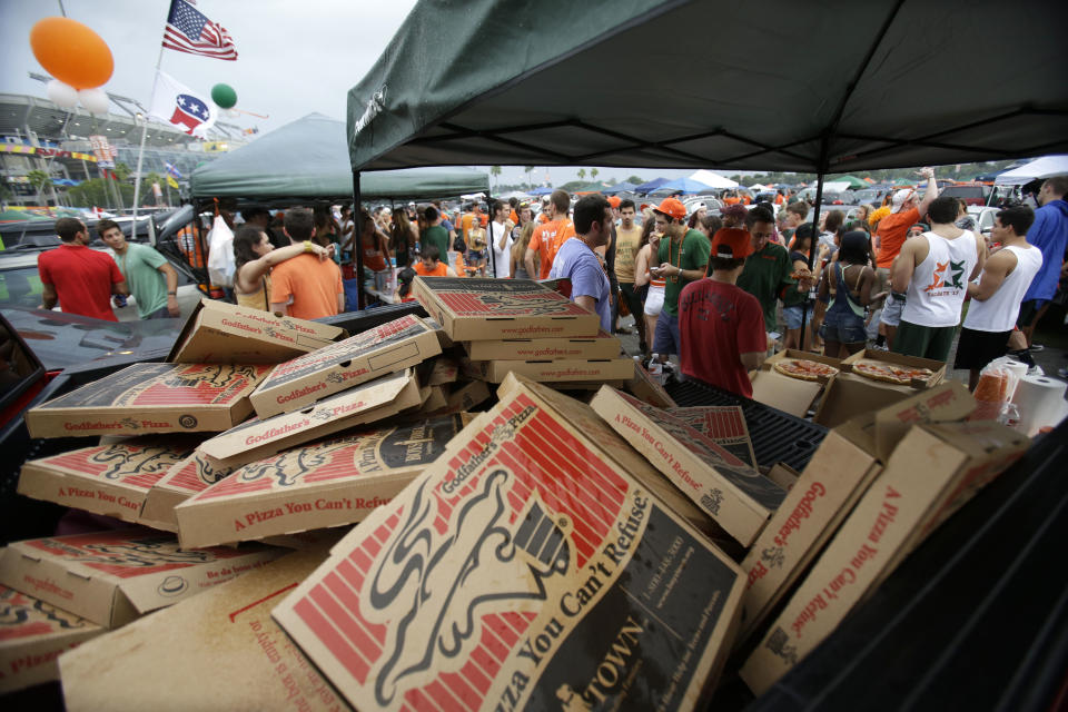 In this Saturday, Nov. 9, 2013 photo, a pickup truck bed full of empty pizza boxes is shown near a row of tents flying an American and Republican Party flag set up by Generation Opportunity, a national conservative organization that targets young adults, in the parking lot of Sun Life Stadium before the start of an NCAA college football game between Miami and Virginia Tech, in Miami Gardens, Fla. It may be the hottest tailgate party at the University of Miami's homecoming game, but the 100-yard stretch of free pizza and party tents, is also a carefully crafted strategy aimed at getting students to opt out of President Barack Obama's controversial new health law. (AP Photo/Wilfredo Lee)