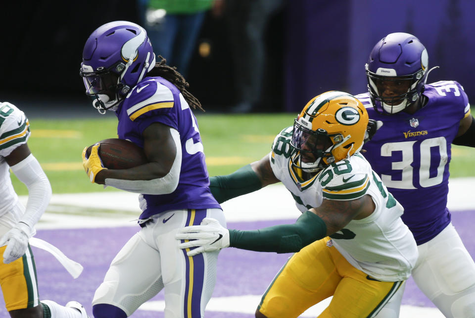 Minnesota Vikings running back Dalvin Cook scores on a 1-yard touchdown run ahead of Green Bay Packers outside linebacker Christian Kirksey (58) during the first half of an NFL football game, Sunday, Sept. 13, 2020, in Minneapolis. (AP Photo/Bruce Kluckhohn)