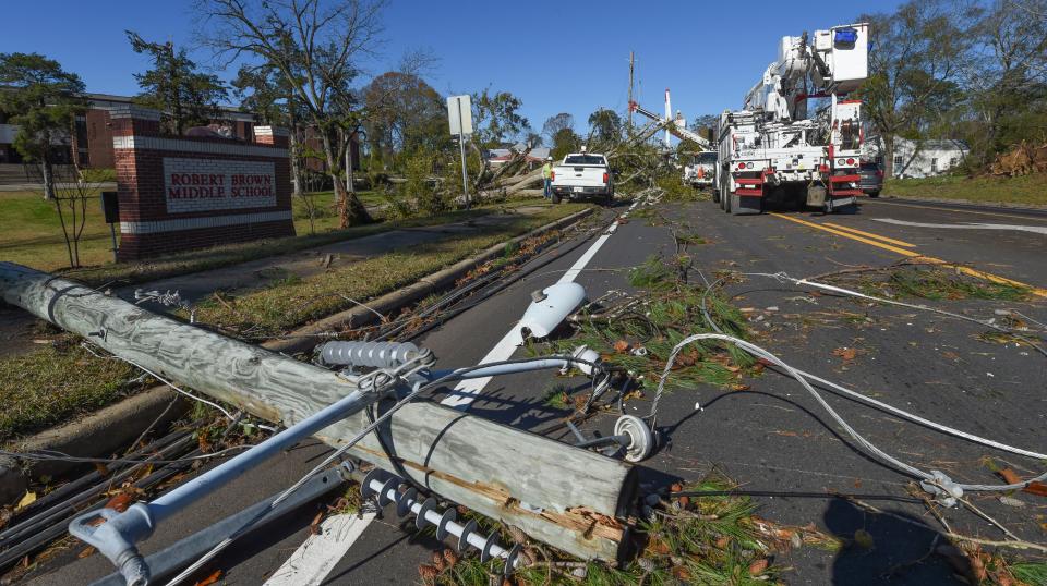 Nov 30, 2022; Eutaw, Alabama, USA;  in Eutaw, Ala., A line crew from Alabama Power works to restore downed power lines along Highway 14 in front of the Robert Brown Middle School in Eutaw after a small tornado hit the town located in Greene County Tuesday, Nov. 29, 2022. No injuries were reported from the storm.