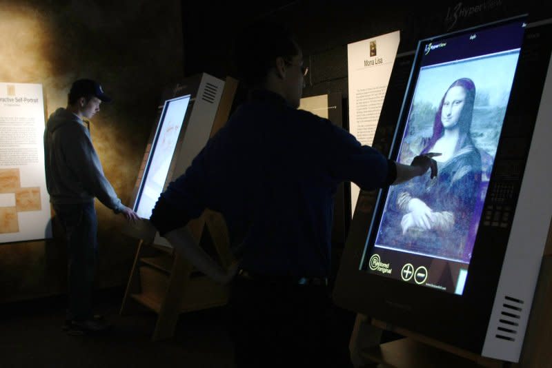 People use touch-screen computers to study details of the "Mona Lisa" painting at the "Leonardo da Vinci's Workshop: Inventor, Artist, Dreamer" exhibit shown at the Discovery Times Square Exposition on November 20, 2009 in New York. On August 21, 1911, the "Mona Lisa" was stolen from the Louvre. The painting by Leonardo di Vinci was recovered in 1913. File Photo by Monika Graff/UPI