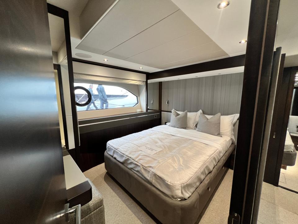 A guest cabin with a double bed and grey walls viewed from the doorway, onboard a Sunseeker 76 yacht