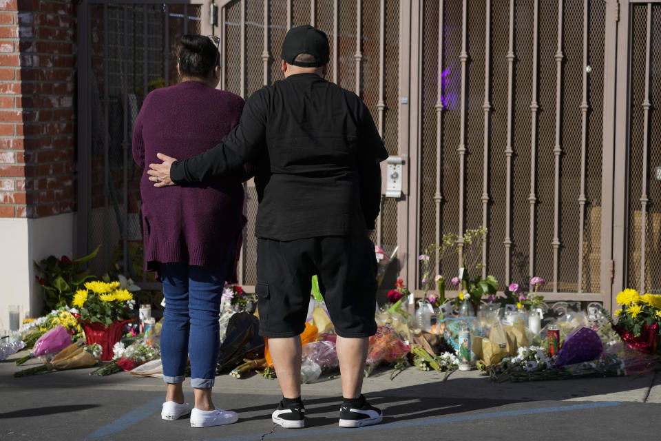 A couple pauses at a memorial outside the Star Ballroom Dance Studio on Monday, Jan. 23, 2023, in Monterey Park, Calif. A gunman killed multiple people at the ballroom dance studio late Saturday amid Lunar New Year's celebrations in the predominantly Asian American community. (AP Photo/Ashley Landis)
