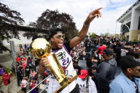 Toronto Raptors guard Kyle Lowry gestures to fans while holding the Larry O'Brien Championship Trophy during the 2019 Toronto Raptors NBA basketball championship parade in Toronto, Monday, June 17, 2019. (Photo by Frank Gunn/The Canadian Press via AP)