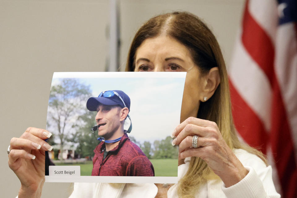 Linda Beigel Schulman holds a photograph of her son, Scott Beigel, before giving her victim impact statement during the penalty phase of Marjory Stoneman Douglas High School shooter Nikolas Cruz's trial at the Broward County Courthouse in Fort Lauderdale, Fla., Monday, Aug. 1, 2022. Beigel Schulman's son, Scott Beigel, was killed in the 2018 shootings. Cruz previously plead guilty to all 17 counts of premeditated murder and 17 counts of attempted murder in the 2018 shootings. (Amy Beth Bennett/South Florida Sun Sentinel via AP, Pool)