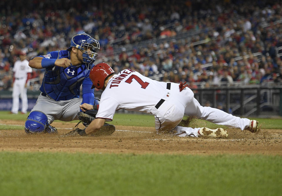 Washington Nationals' Trea Turner scores against Chicago Cubs catcher Willson Contreras, left, during the sixth inning of the first baseball game of a doubleheader, Saturday, Sept. 8, 2018, in Washington. (AP Photo/Nick Wass)