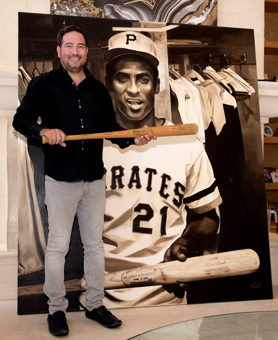 Standing in front of a painting by artist Kait Schoeb, Dr. Rob Shelling, of Boca Raton, has the bat that Roberto Clemente used in his 3,000 hit and also the final hit of his career before he died in a plane crash in 1972.