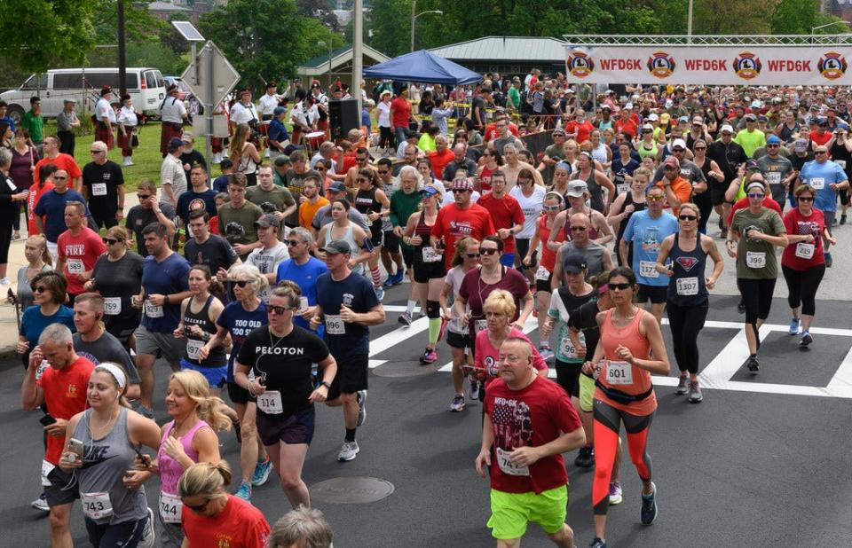 Runners stream down Institute Street at the start of the Worcester Firefighters 6K.